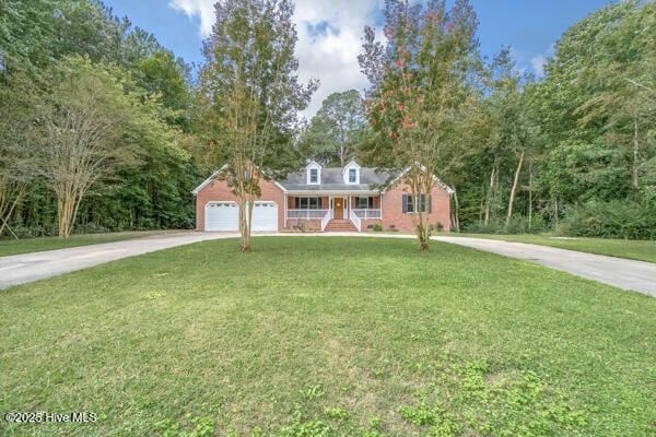 view of front of property featuring a garage, a porch, and a front yard