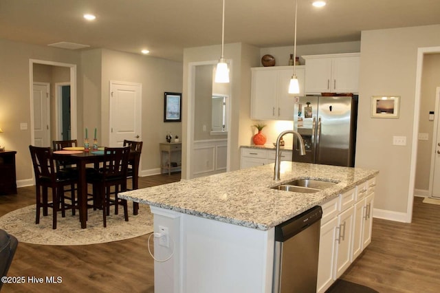 kitchen featuring pendant lighting, a kitchen island with sink, white cabinets, sink, and stainless steel appliances