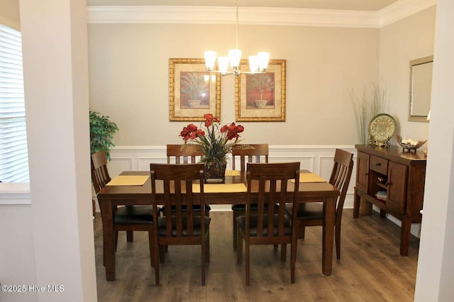 dining space featuring a chandelier, ornamental molding, and dark wood-type flooring