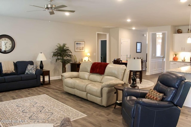 living room with ceiling fan and light hardwood / wood-style flooring