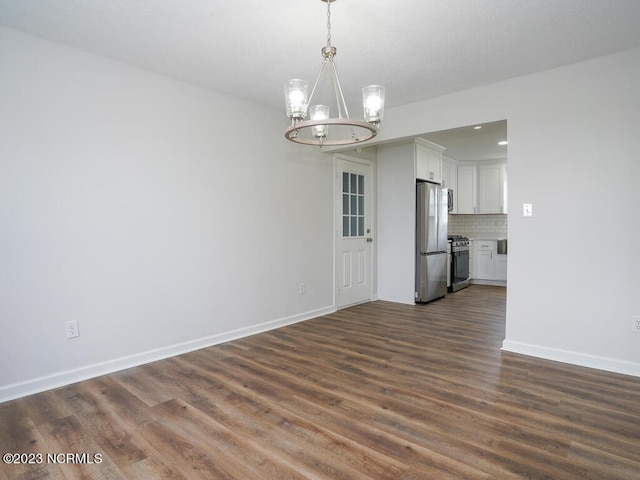 unfurnished dining area with dark hardwood / wood-style floors and an inviting chandelier