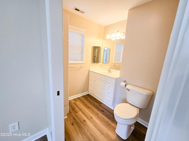 bathroom featuring wood-type flooring, toilet, and vanity