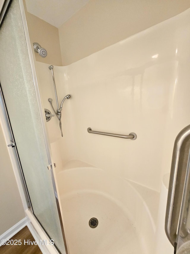 bathroom with hardwood / wood-style flooring and a shower