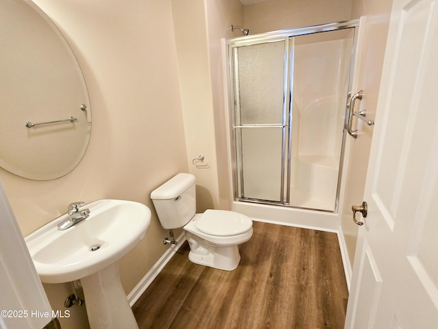 bathroom with walk in shower, wood-type flooring, and toilet