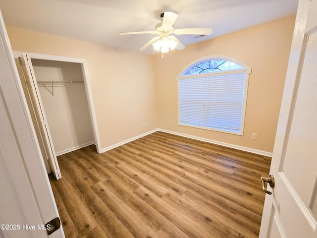 unfurnished bedroom with hardwood / wood-style flooring, a closet, and ceiling fan