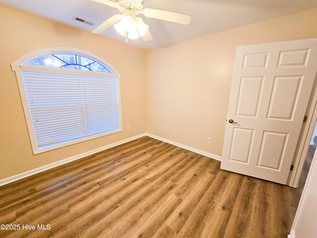 empty room with ceiling fan and hardwood / wood-style floors