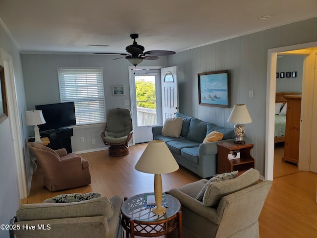 living room featuring light hardwood / wood-style floors, ceiling fan, and ornamental molding