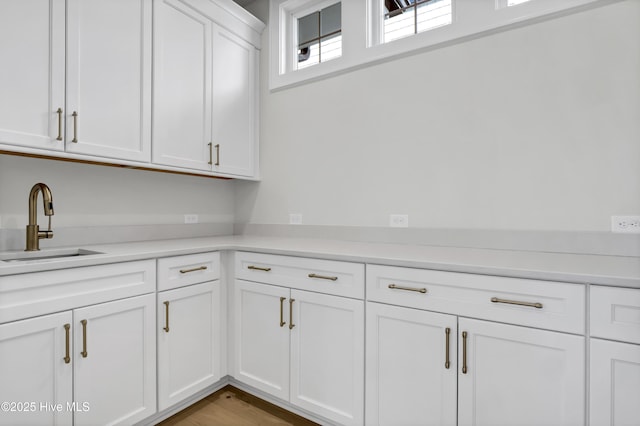 kitchen featuring white cabinetry, sink, and light hardwood / wood-style floors