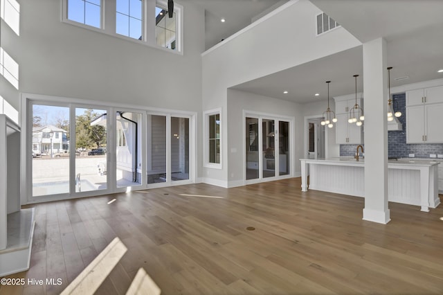 unfurnished living room featuring hardwood / wood-style flooring and sink