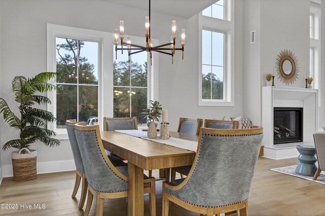 dining space with light hardwood / wood-style flooring and a chandelier