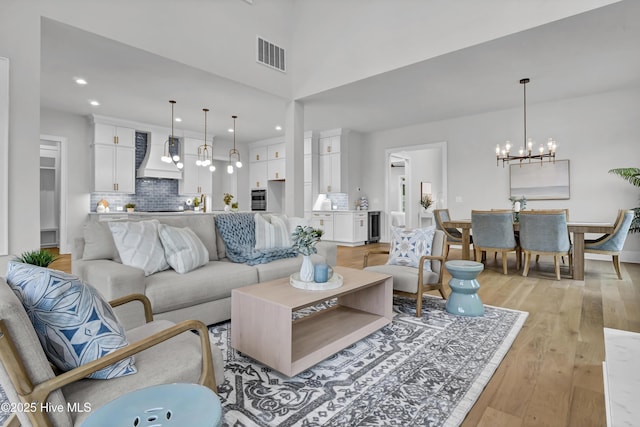 living room with an inviting chandelier and light wood-type flooring