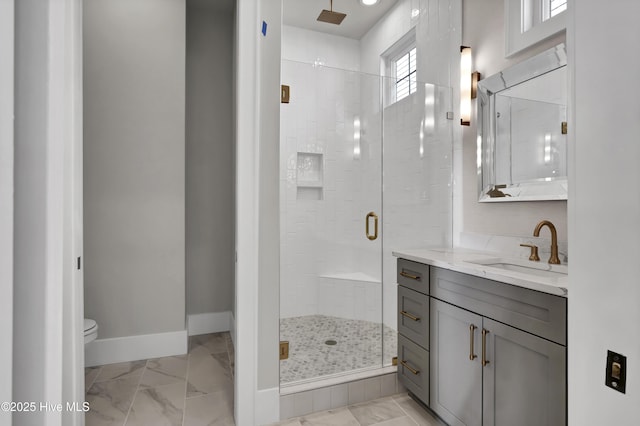 bathroom featuring a shower with door, vanity, and toilet