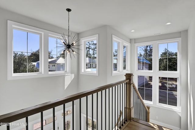 hall with plenty of natural light and a chandelier