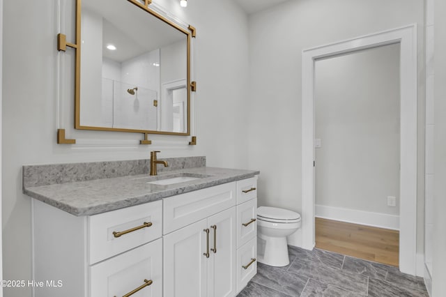 bathroom with vanity, toilet, and walk in shower