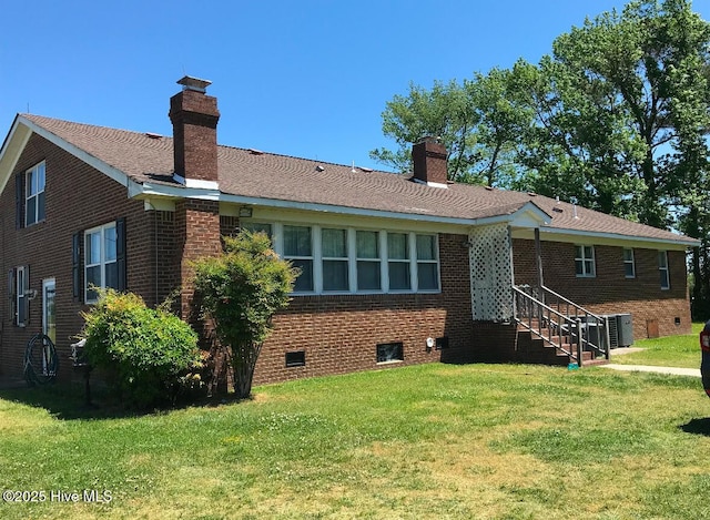 rear view of property featuring a lawn