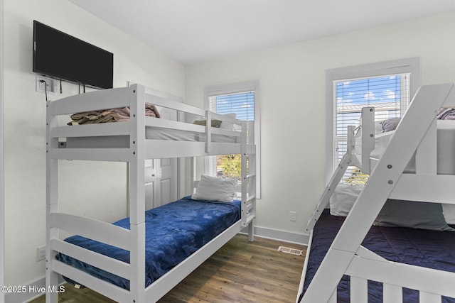 bedroom with visible vents, baseboards, and wood finished floors