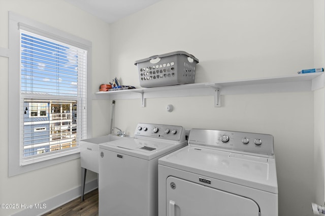 washroom with baseboards, separate washer and dryer, dark wood-style floors, and laundry area