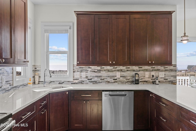 kitchen featuring light countertops, tasteful backsplash, appliances with stainless steel finishes, and a sink