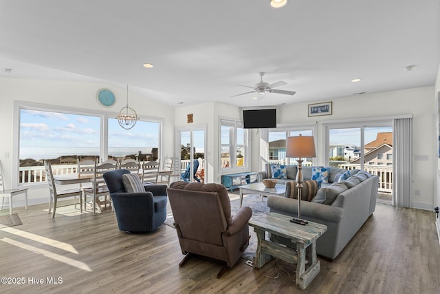 living room featuring recessed lighting, lofted ceiling, wood finished floors, and ceiling fan with notable chandelier