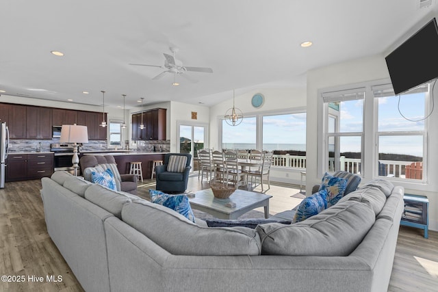 living area featuring recessed lighting, lofted ceiling, light wood-style floors, and a ceiling fan