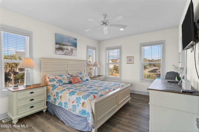 bedroom featuring a ceiling fan, visible vents, dark wood-style flooring, and baseboards