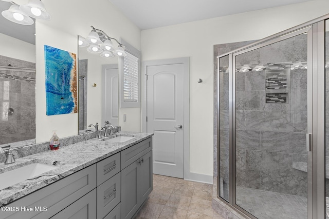 bathroom featuring a sink, double vanity, and a shower stall