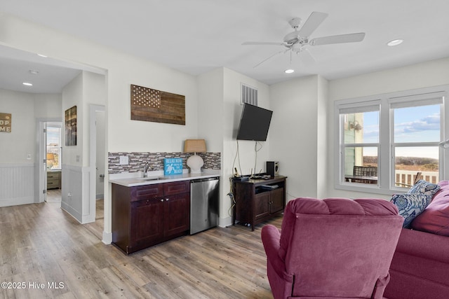 living area featuring a wainscoted wall, light wood-style flooring, recessed lighting, and visible vents