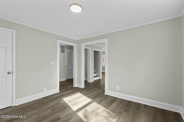 unfurnished bedroom with crown molding and dark wood-type flooring