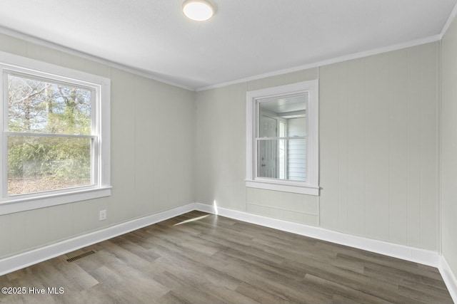 empty room featuring crown molding and wood-type flooring