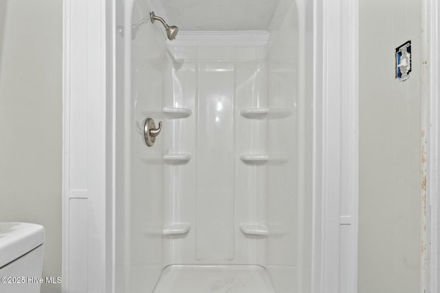 bathroom featuring a shower, a textured ceiling, and ornamental molding