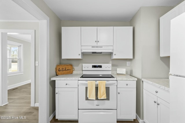 kitchen with white cabinets, light wood-type flooring, and white appliances