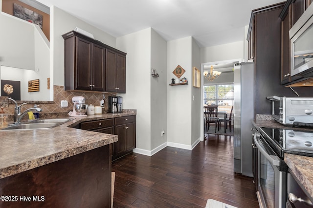 kitchen featuring backsplash, an inviting chandelier, sink, dark brown cabinetry, and stainless steel appliances