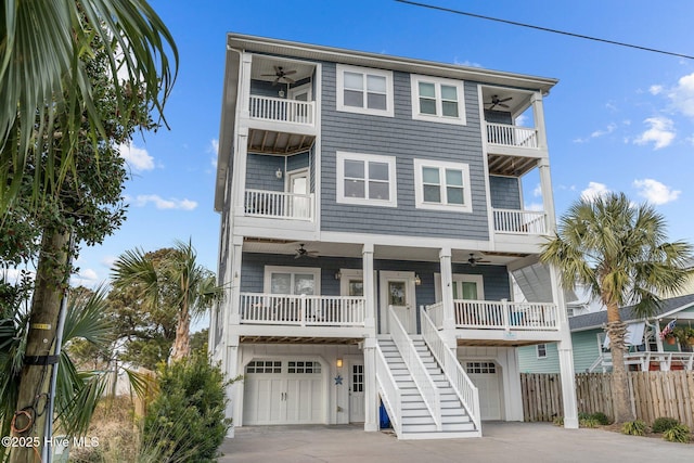 coastal home featuring a garage, a porch, and ceiling fan