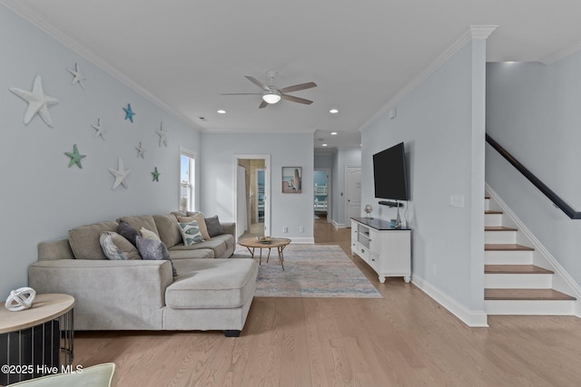 living room with ornamental molding, ceiling fan, and light wood-type flooring