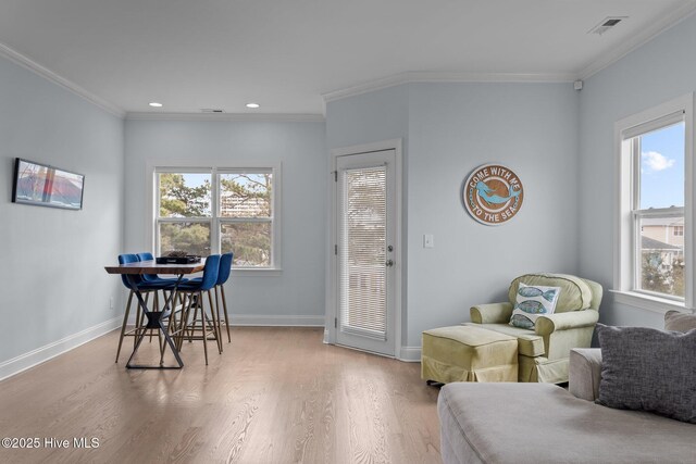 bedroom featuring multiple closets, light hardwood / wood-style flooring, ornamental molding, and ceiling fan