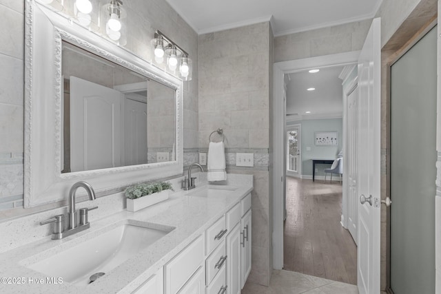 bathroom featuring crown molding, vanity, tile patterned flooring, and tile walls