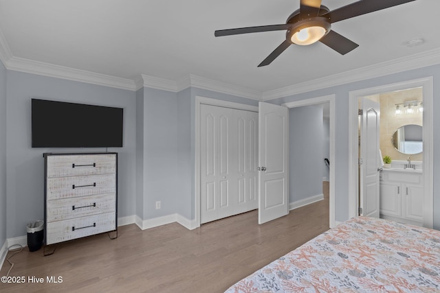 bedroom featuring ensuite bathroom, sink, light wood-type flooring, ornamental molding, and a closet