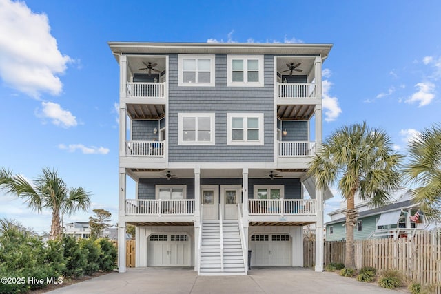 raised beach house with ceiling fan, a garage, and covered porch