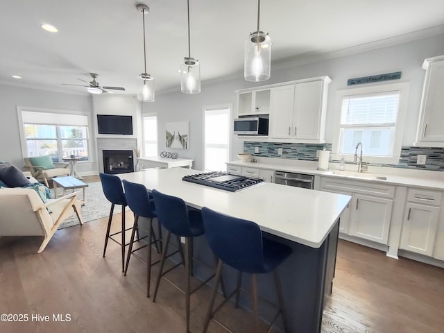 kitchen with white cabinetry, appliances with stainless steel finishes, sink, and a kitchen island