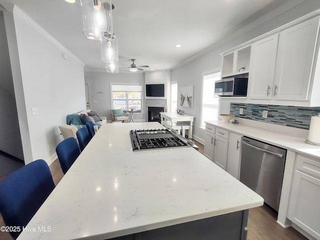 kitchen featuring white cabinetry, appliances with stainless steel finishes, and decorative light fixtures