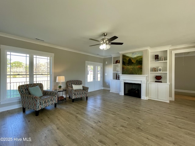 interior space with hardwood / wood-style floors, ceiling fan, a wealth of natural light, and built in shelves