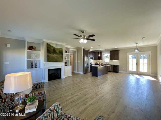 living room with french doors, light hardwood / wood-style flooring, ceiling fan, and ornamental molding