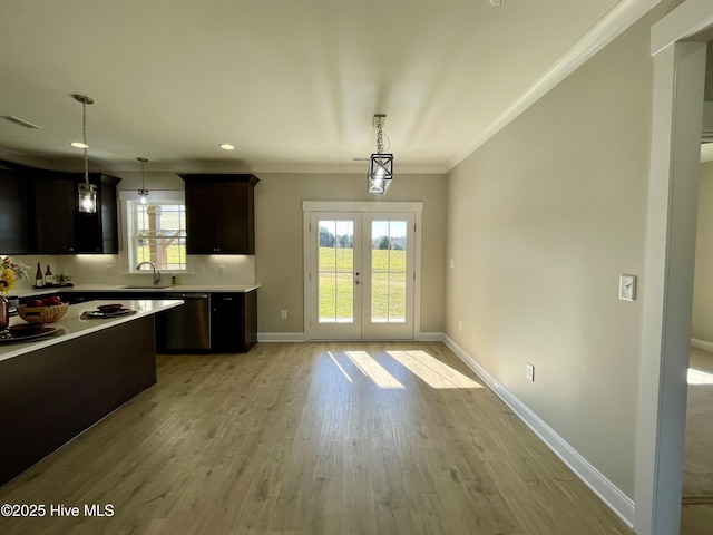 kitchen with pendant lighting, light hardwood / wood-style floors, ornamental molding, and french doors