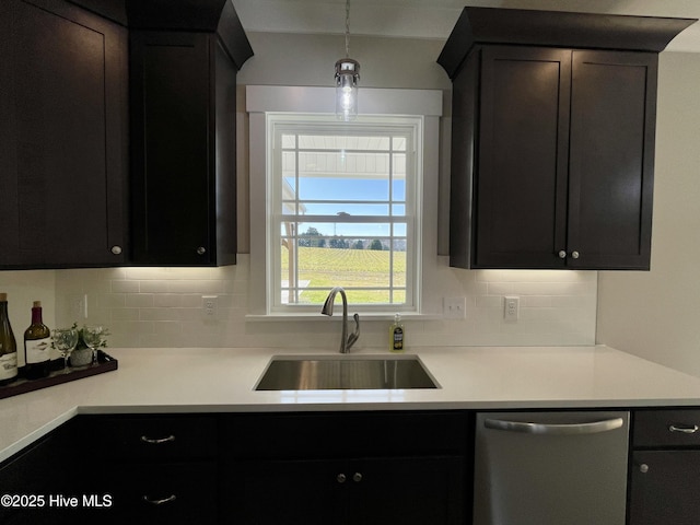 kitchen featuring backsplash, dishwasher, hanging light fixtures, and sink