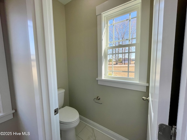 bathroom with toilet and a wealth of natural light