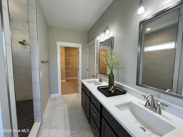 bathroom with a tile shower and vanity