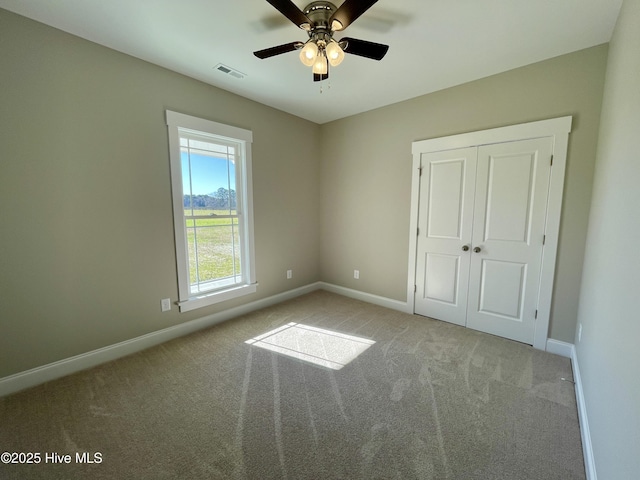 unfurnished bedroom with light carpet, a closet, and ceiling fan