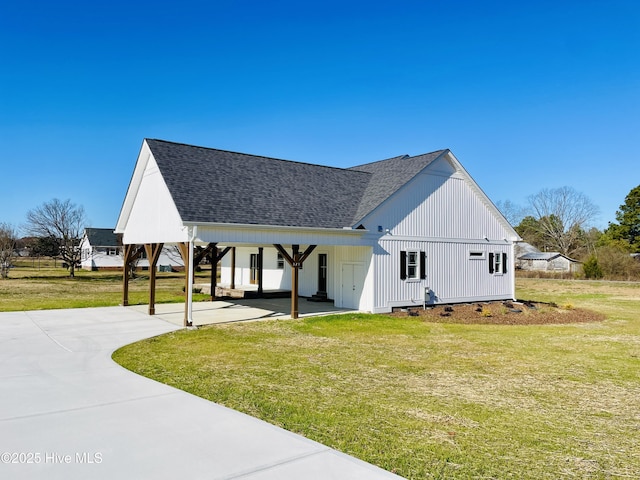 view of side of property with a carport and a lawn