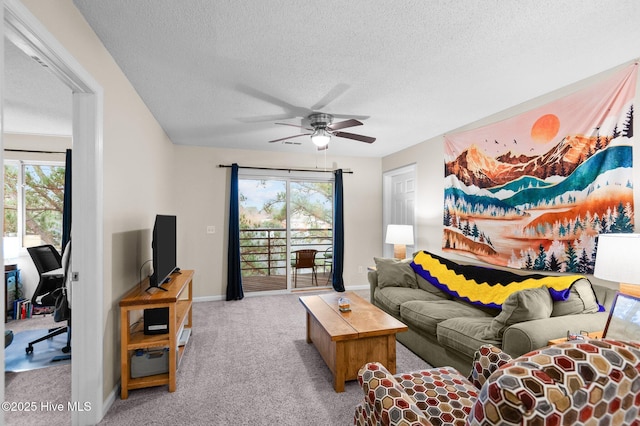 carpeted living room featuring ceiling fan and a textured ceiling