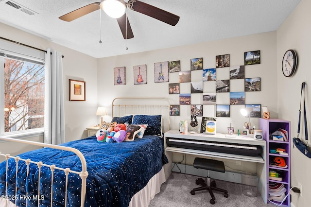 carpeted bedroom featuring a textured ceiling and ceiling fan